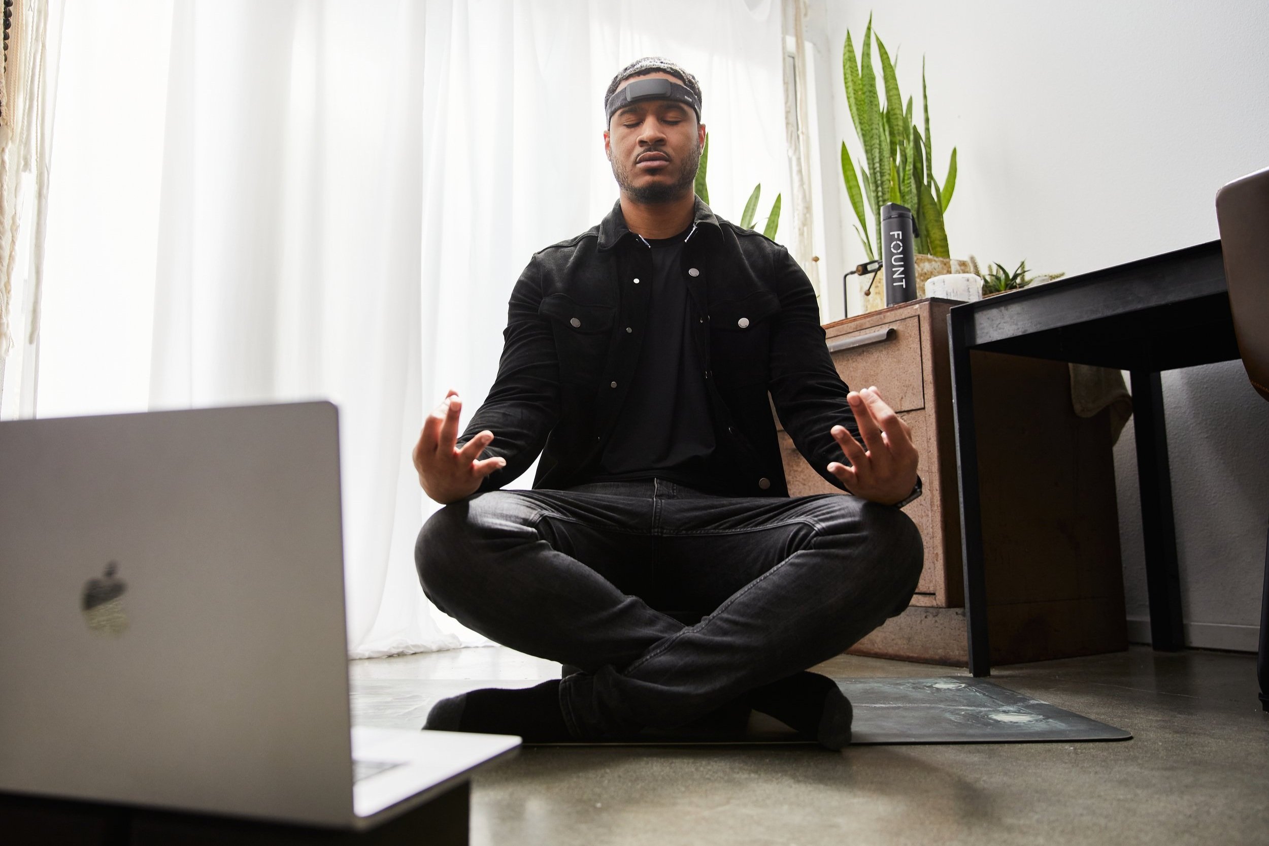 Man meditating wearing a Fount wellness headband