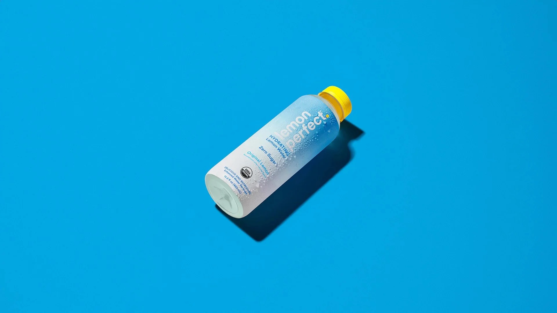 Lemon Perfect bottle on blue, Original Lemon hydrating lemon water