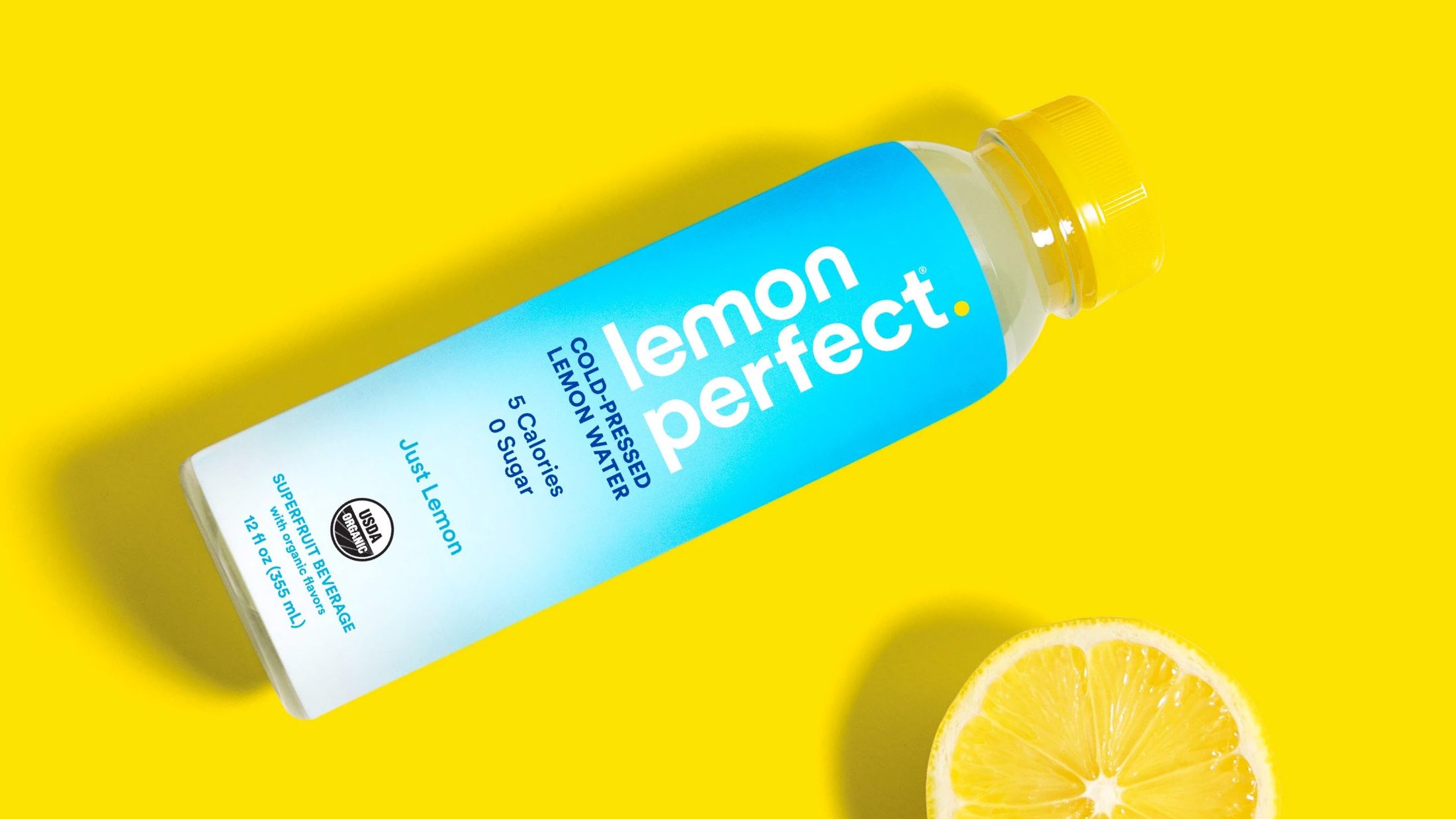 Lemon Perfect bottle and lemon slice on yellow